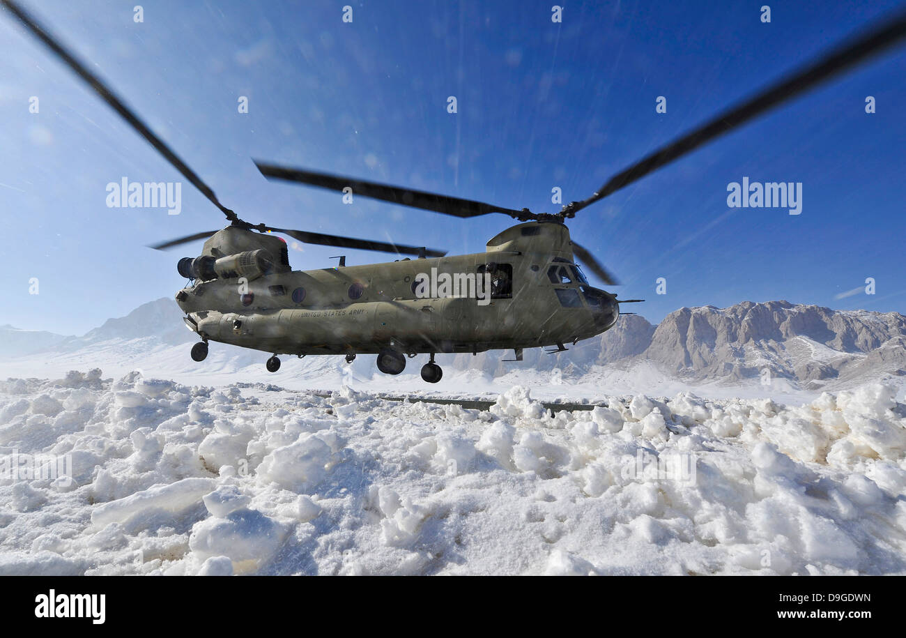 Neve vola in alto come un U.S. Esercito CH-47 elicottero Chinook si prepara a terra Foto Stock