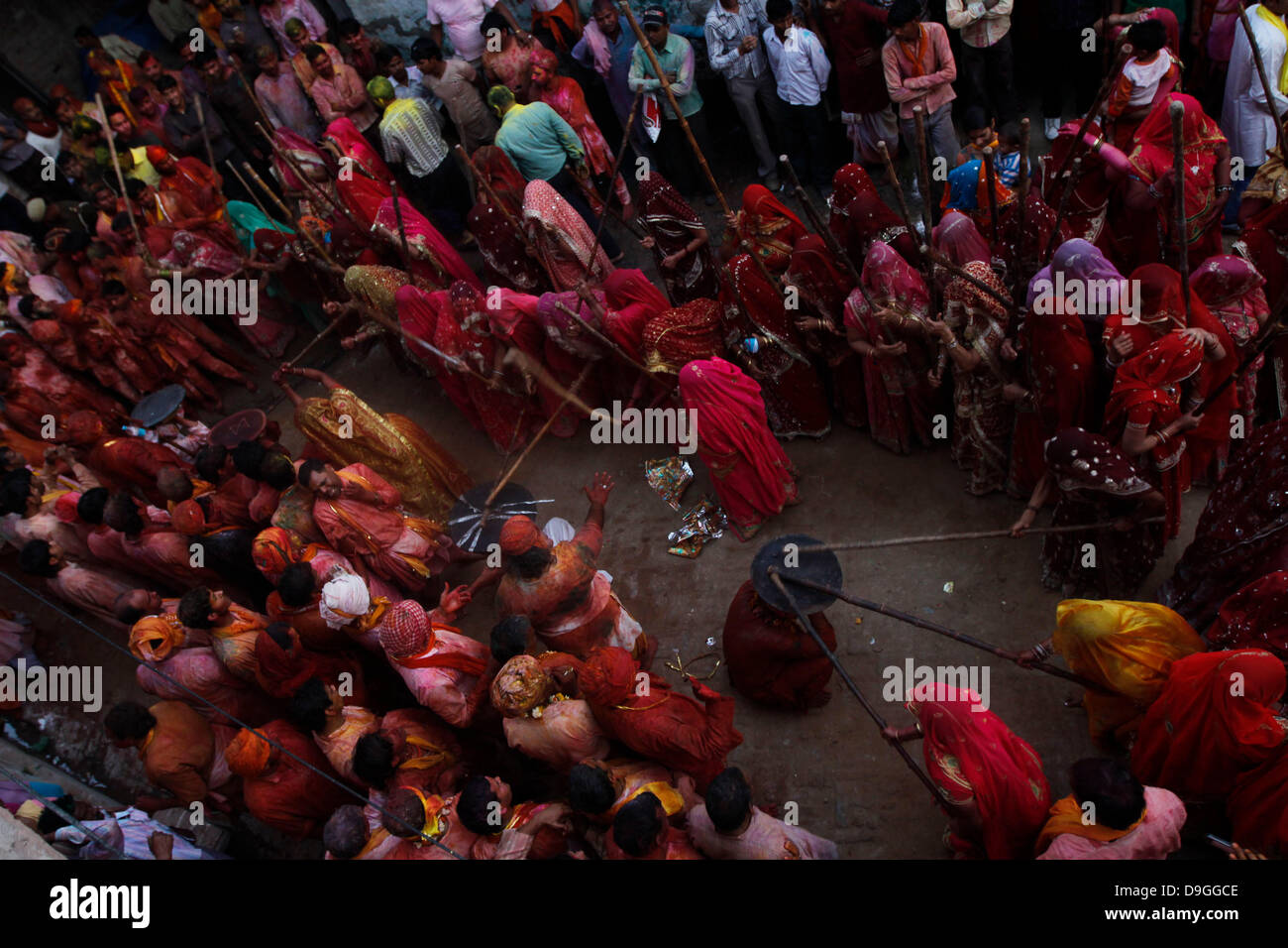 Indian gli uomini cercano di proteggere se stessi con uno scudo come donne batterli con bastoni durante la celebrazione della festa della primavera di Holi nel nord del villaggio di Nandgaon, Mathura, Martedì, Marzo 15, 2011. Nandgaon, Mathura, India - 15.03.11 Foto Stock