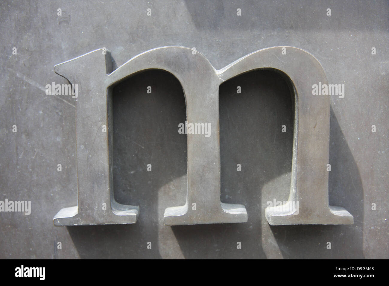 Grande lettera metallica M installata sulla superficie di un muro Foto Stock
