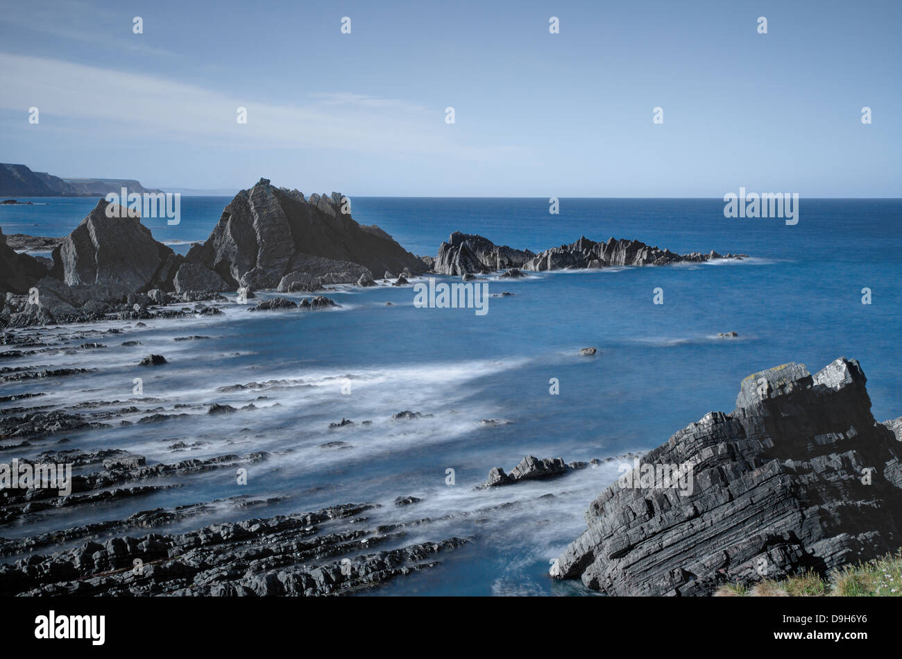 La marea su questa pittoresca ancora drammaticamente spiaggia robusto a Hartland Quay sulla North Devon Coast Foto Stock