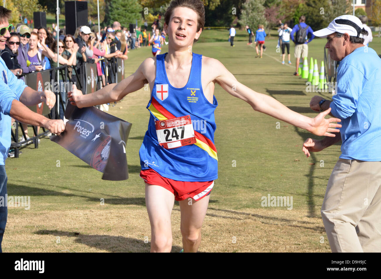 Adolescente attraversa la linea del traguardo dopo una corsa in una scuola di cross country match Foto Stock
