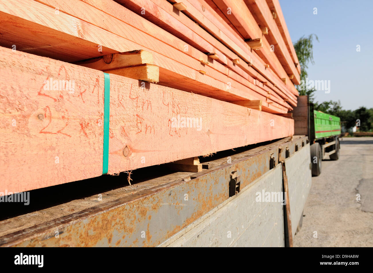 Trave di legno e tavole caricato su un camion rimorchio Foto Stock