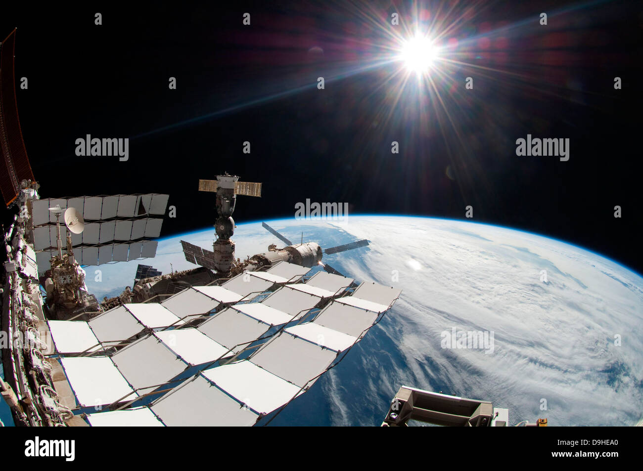 Il sole luminoso, una porzione della Stazione Spaziale Internazionale e la massa di orizzonte. Foto Stock