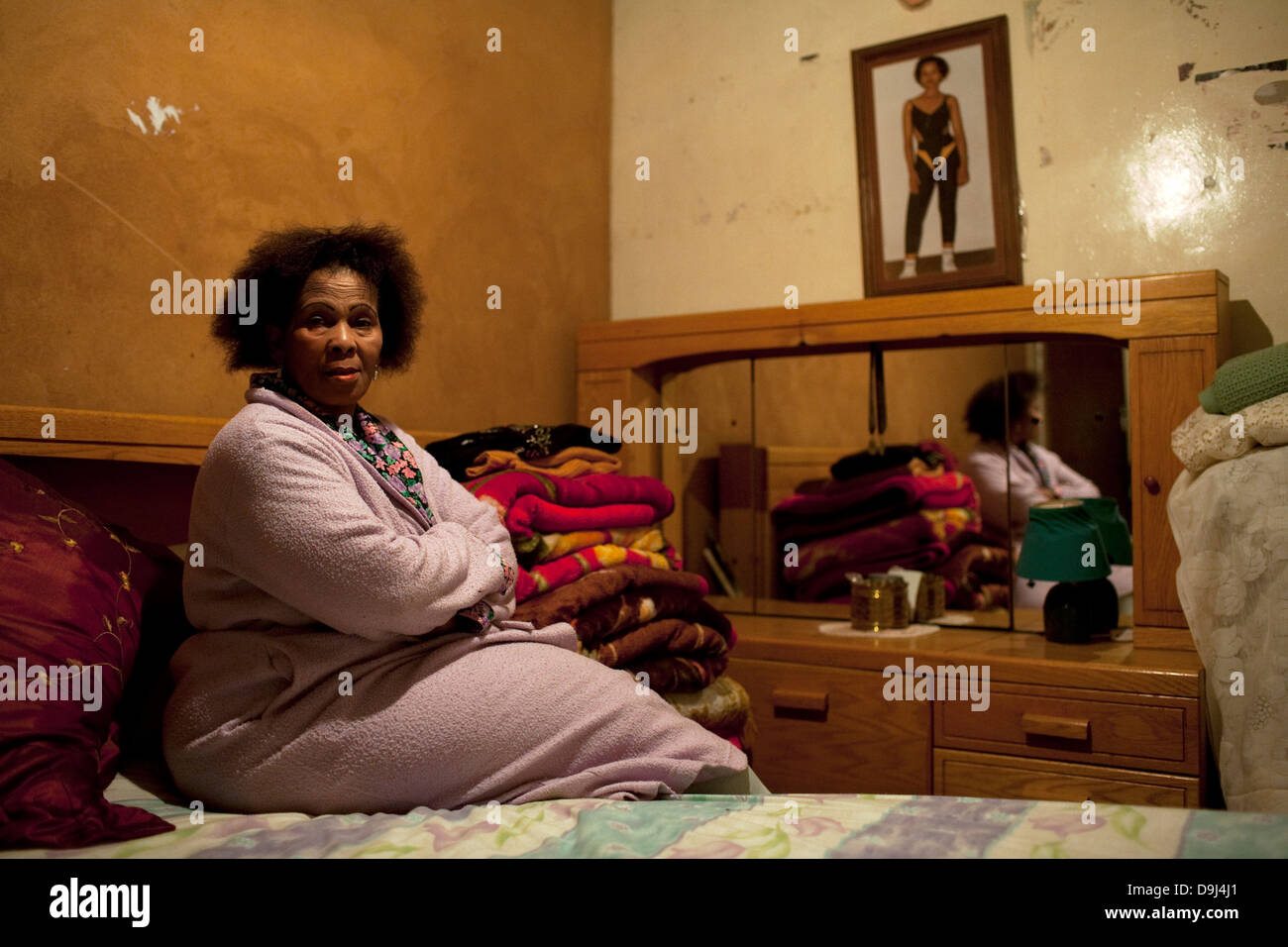 Alina Thonjeni 69 siede nella camera da letto di fronte toeletta immagine figlia è sulla parete si ritirò il lavoro al fine di convertire Foto Stock