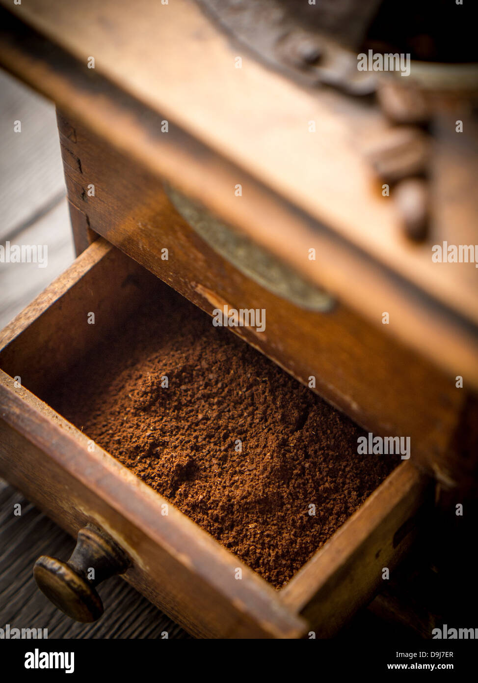 Macinare i chicchi di caffè in un legno vecchio macinino da caffè. Foto Stock