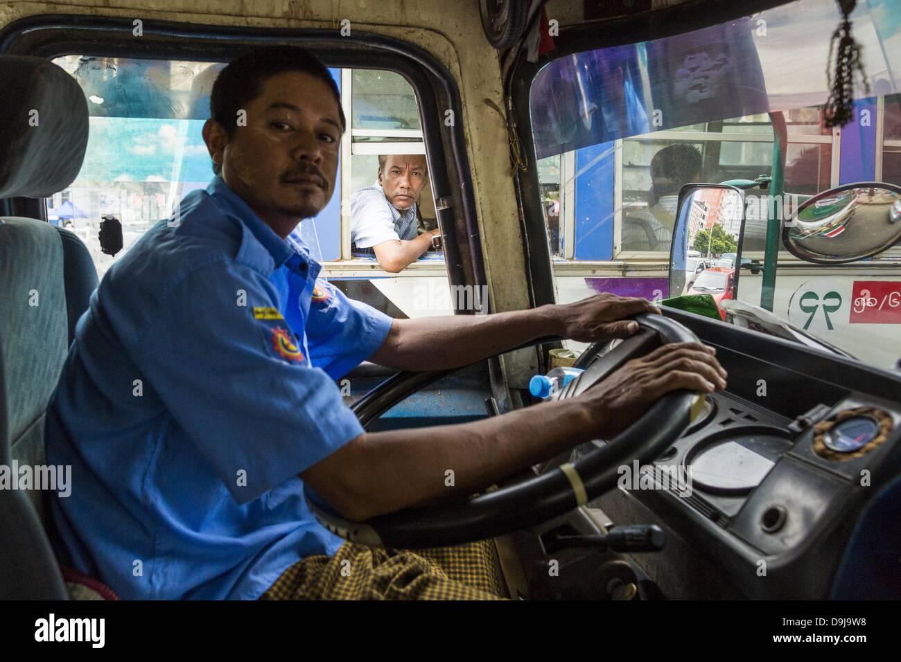 Giugno 19, 2013 - Yangon, Unione di Myanmar - un passeggero scale fuori dalla finestra di Yangon bus come un altro autobus che passa a lui. Yangon gli autobus sono generalmente sovraffollati e in cattive condizioni di riparazione ma come l'economia migliora di versione più recente, ma ancora usato, il giapponese e il coreano autobus vengono importati. Centinaia di linee di autobus criss-cross Yangon, fornendo il modo più conveniente di andare in giro per la città. La maggior parte delle tariffe sono inferiori all'equivalente di .20â ¢ noi. (Credito Immagine: © Jack Kurtz/ZUMAPRESS.com) Foto Stock