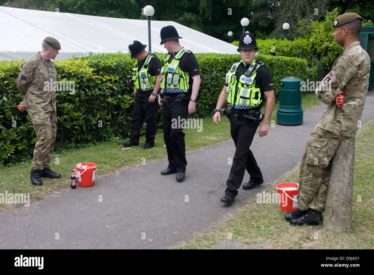 La Thames Valley Police ufficiali a piedi passato che serve le guardie Coldstream soldati raccogliendo denaro per carità durante l annuale Royal Ascot festival di corse di cavalli in Berkshire, Inghilterra. Royal Ascot è uno d'Europa più famosa corsa incontri, e risale al 1711. Queen Elizabeth e vari membri della famiglia reale britannica partecipare. Tenuto ogni anno a giugno, è uno dei principali date in inglese calendario sportivo e sociale di estate stagione. Oltre 300.000 persone rendono la visita annuale a Berkshire durante il Royal Ascot settimana, rendendo questa Europa più frequentato gara incontro con oltre £3m un premio in denaro per essere vinto. Foto Stock