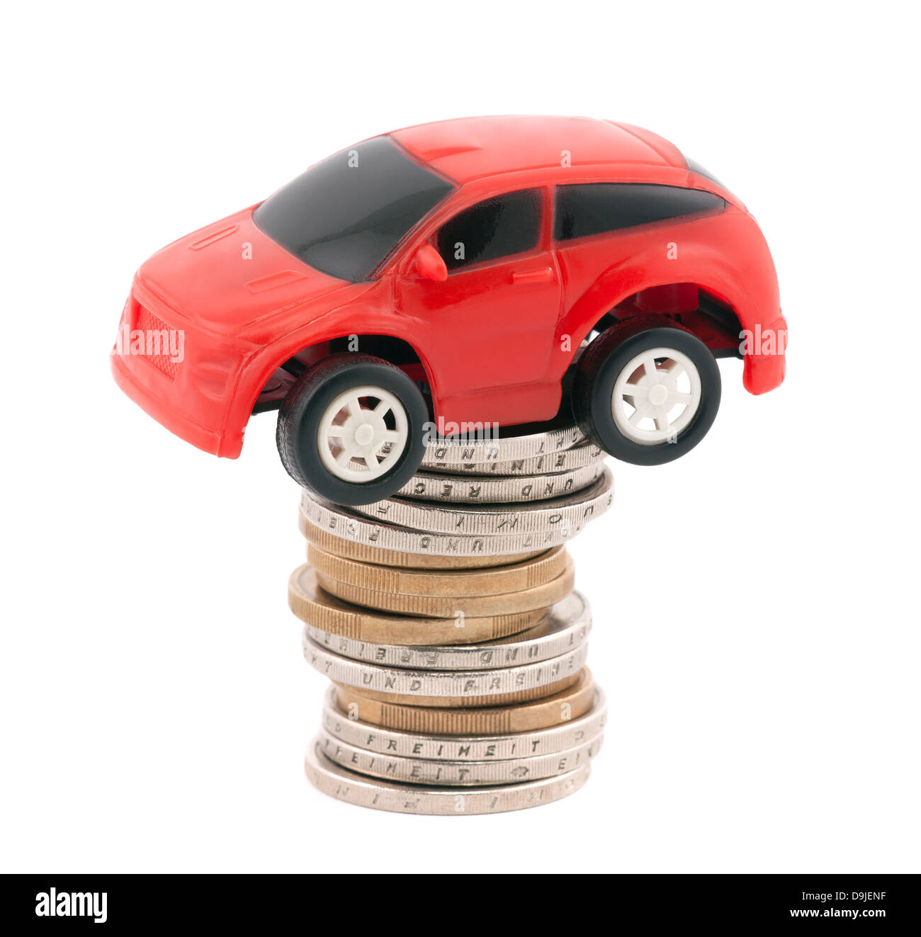 Red giocattolo auto sulla pila di monete metalliche in euro Foto Stock