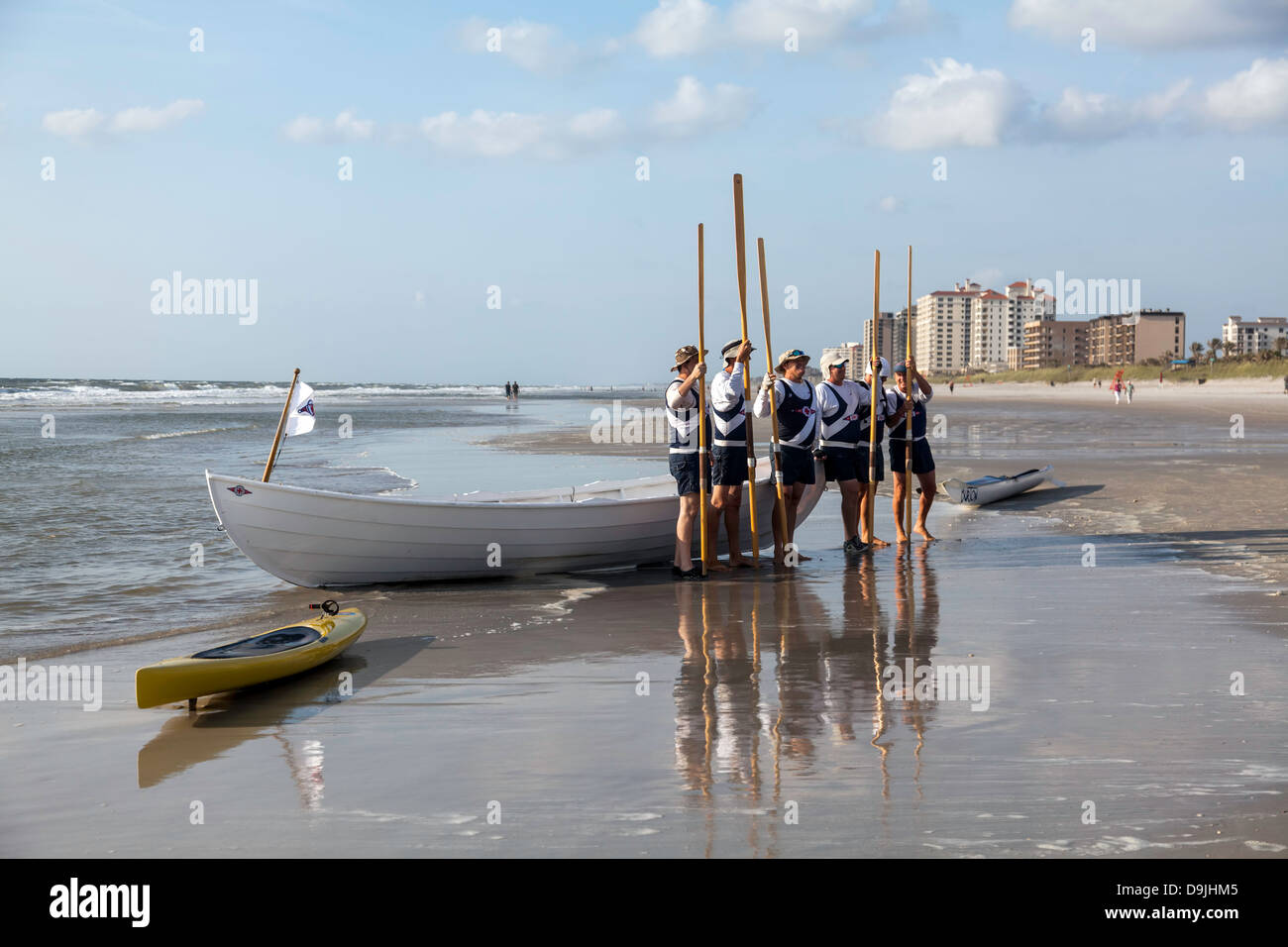 Spiaggia di Jacksonville volontario della Croce Rossa spiaggia la barca di salvataggio equipaggio pongono prima della loro barca a remi in mano. Giallo mare kayak nelle vicinanze. Foto Stock