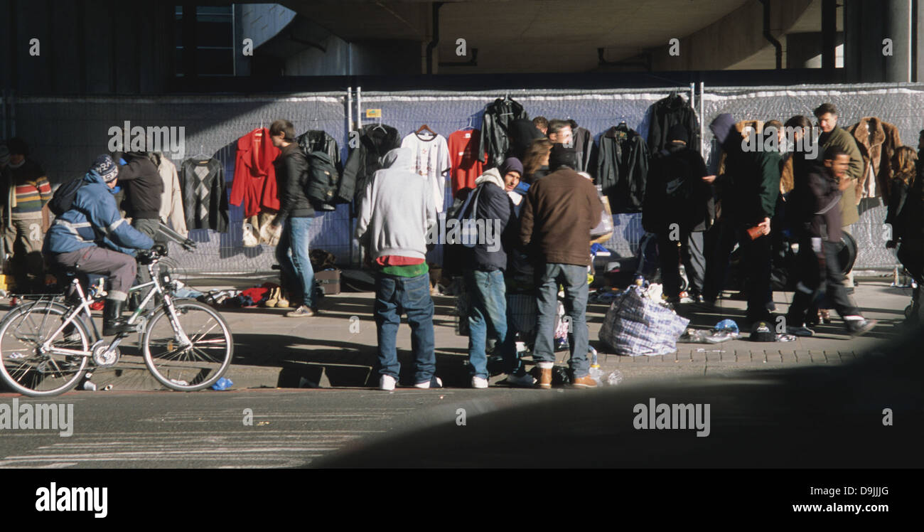 Persone che vendono abiti di seconda mano sul marciapiede, Club Row, Shoreditch, Londra E1, Inghilterra, REGNO UNITO Foto Stock