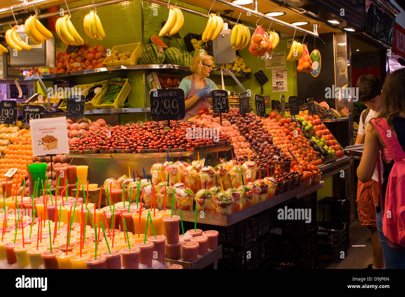 Persone che acquistano la frutta in una fase di stallo nel mercato La Boqueria a Barcellona Spagna Foto Stock