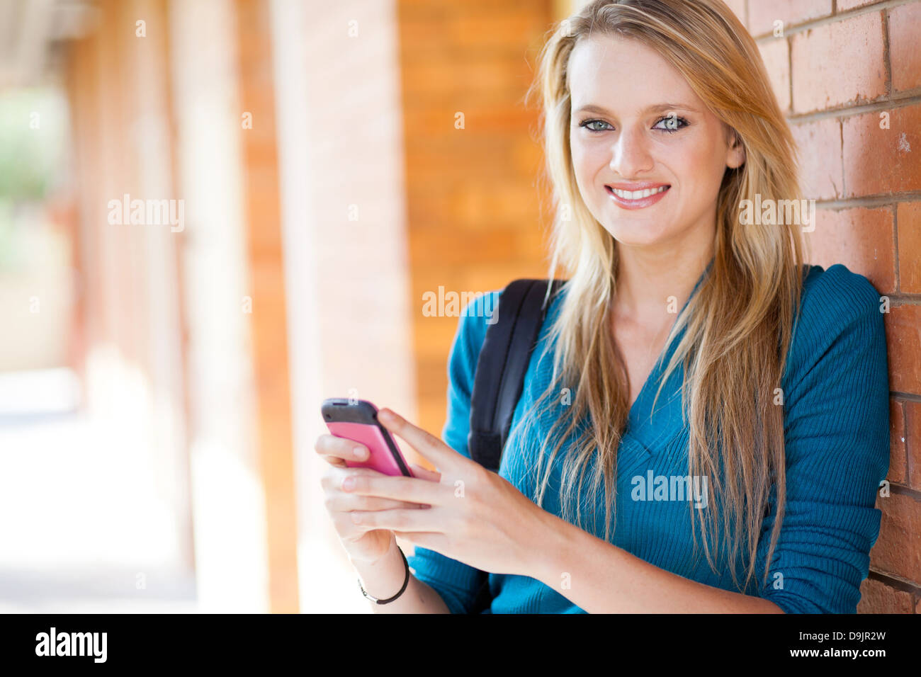 Felice giovane donna l'invio di sms con il telefono cellulare Foto Stock