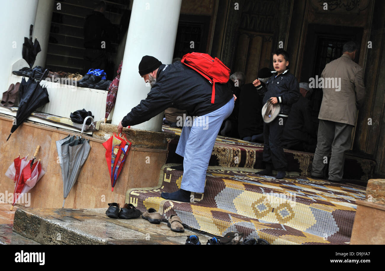 L'uomo prende le sue scarpe fuori prima di entrare in una moschea, la Moschea dipinta (Sarena Dzamija), Tetovo Macedonia Foto Stock