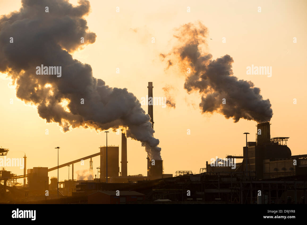 Le emissioni provenienti dalla Ijmuiden, Tata Steel Works, Paesi Bassi al tramonto. Foto Stock