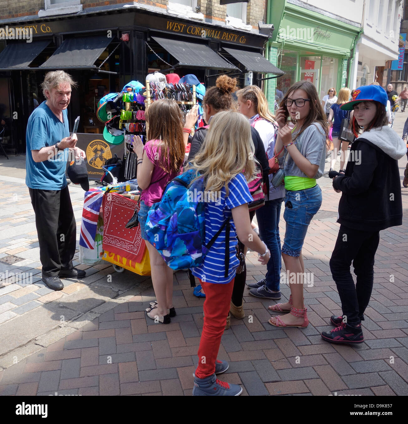 Commerciante di strada che vendono souvenir agli allievi il giorno di viaggio a Canterbury High Street Foto Stock