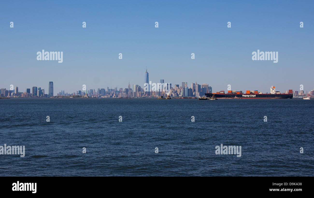 NEW YORK, NY, Stati Uniti d'America - 27 Maggio 2013: un contenitore tedesco nave arriva a New York City prima lo sfondo dello Skyline di Manhattan. Foto Stock