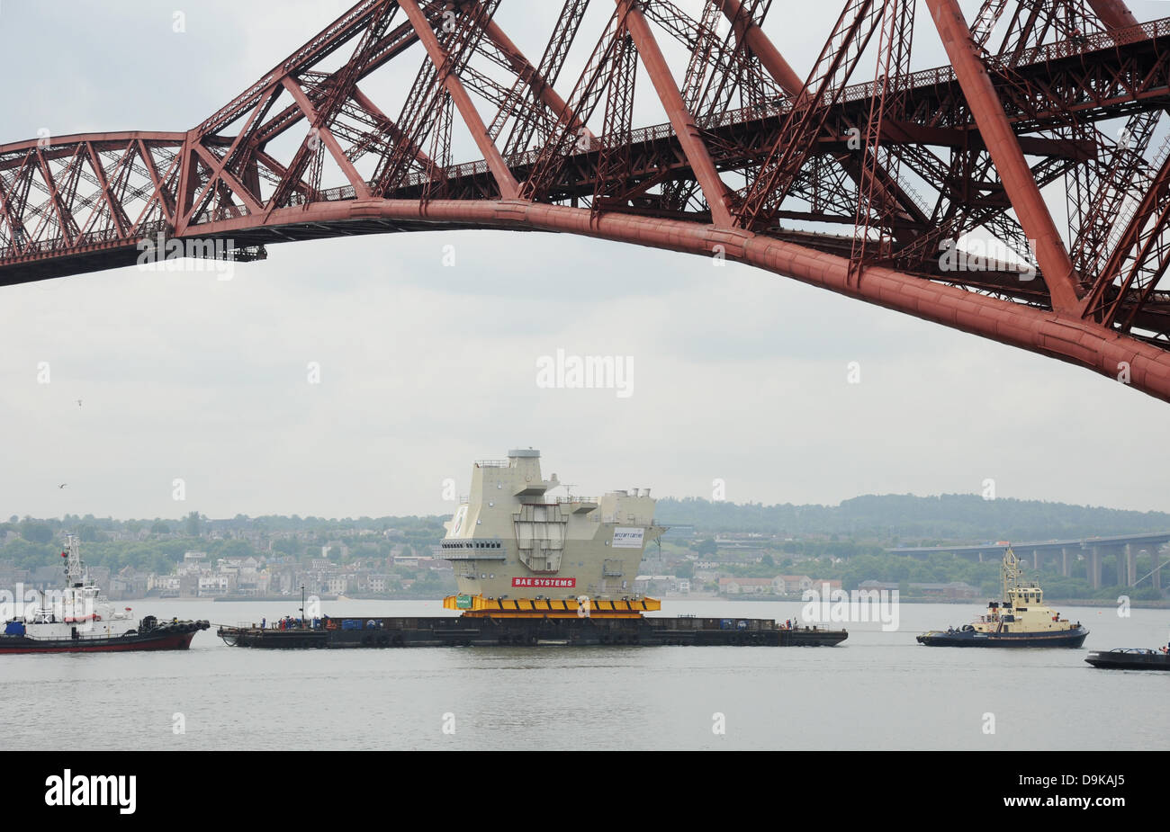 La via, nei pressi di Edimburgo, Regno Unito. Il 21 giugno, 2013. Pezzo finale della nuova portaerei (HMS Queen Elizabeth) entrando sotto il Ponte di Forth vicino a Rosyth. La sezione di portaerei fu costruito in Scotstoun e veniva preso a Rosyth dockyard Credito: Linda Jones/Alamy Live News Foto Stock