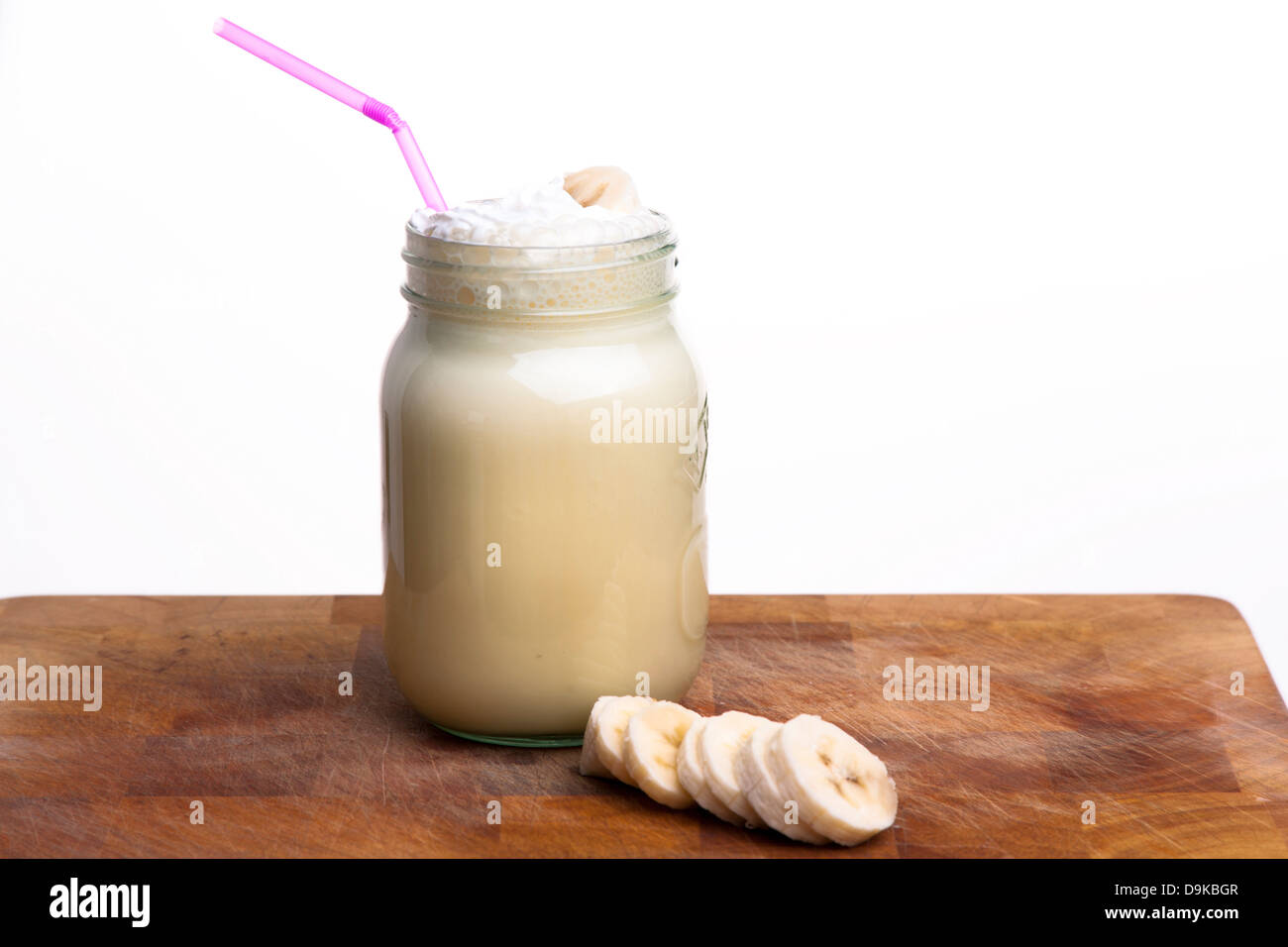 Frullato di banana drink in un vasetto di marmellata con una paglia Foto Stock