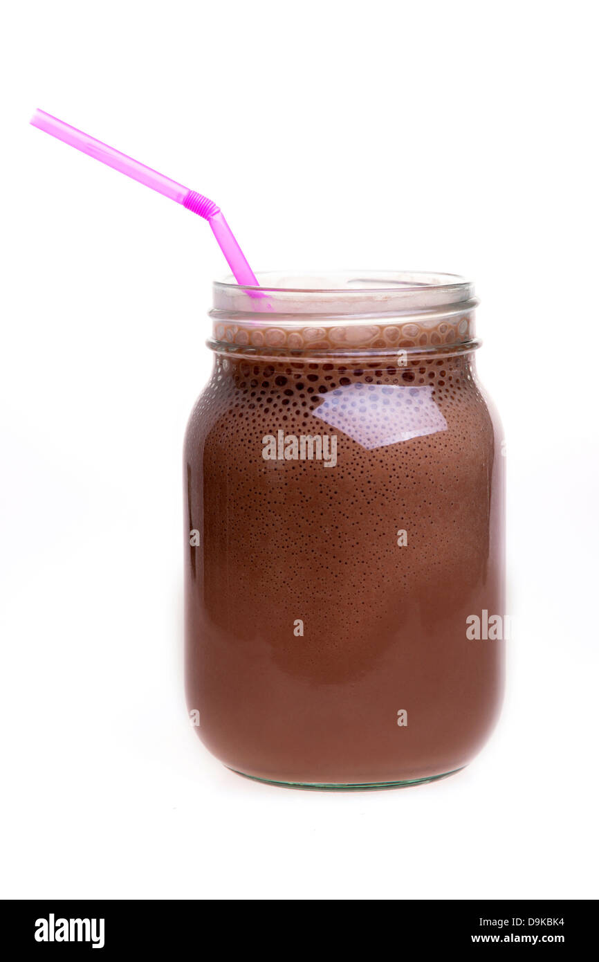 Frullato al cioccolato da bere in un vasetto di marmellata con una paglia Foto Stock
