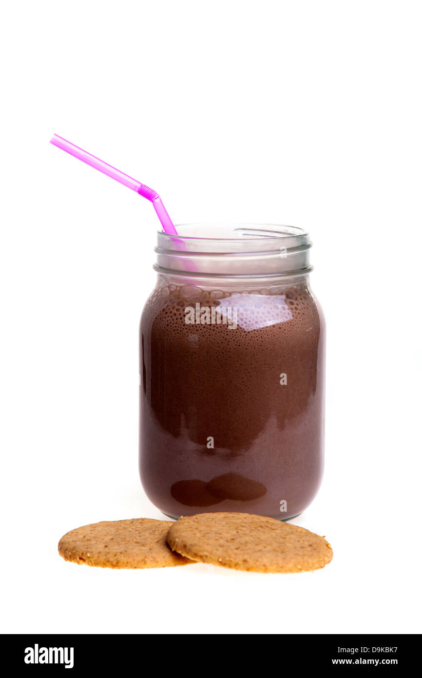 Frullato al cioccolato da bere in un vasetto di marmellata con una cannuccia e cookie Foto Stock
