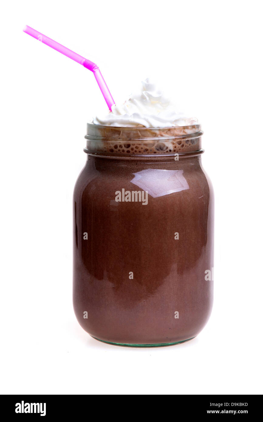 Frullato al cioccolato da bere in un vasetto di marmellata con una cannuccia e panna montata Foto Stock