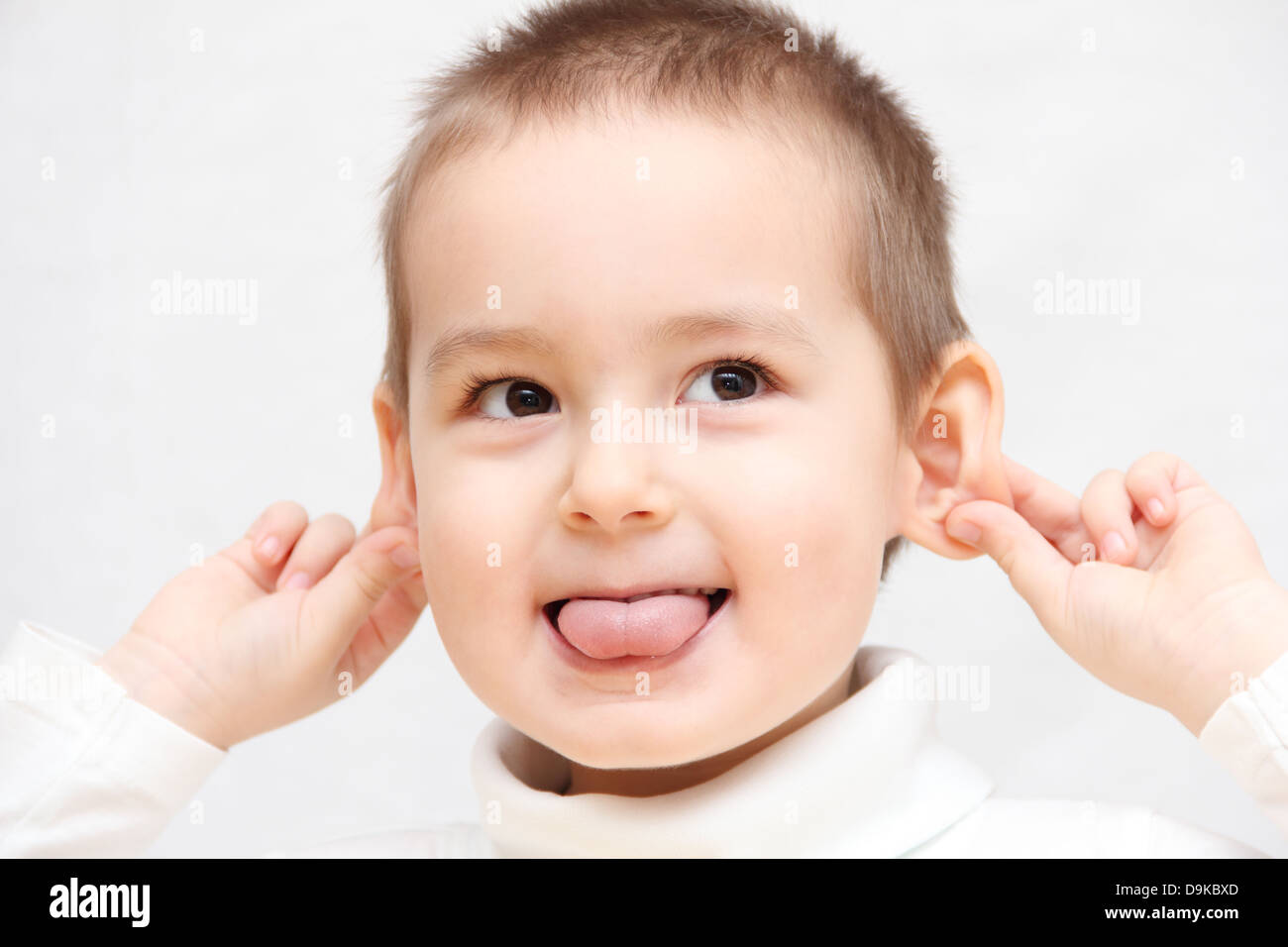 Bambino felice che mostra la linguetta Foto Stock