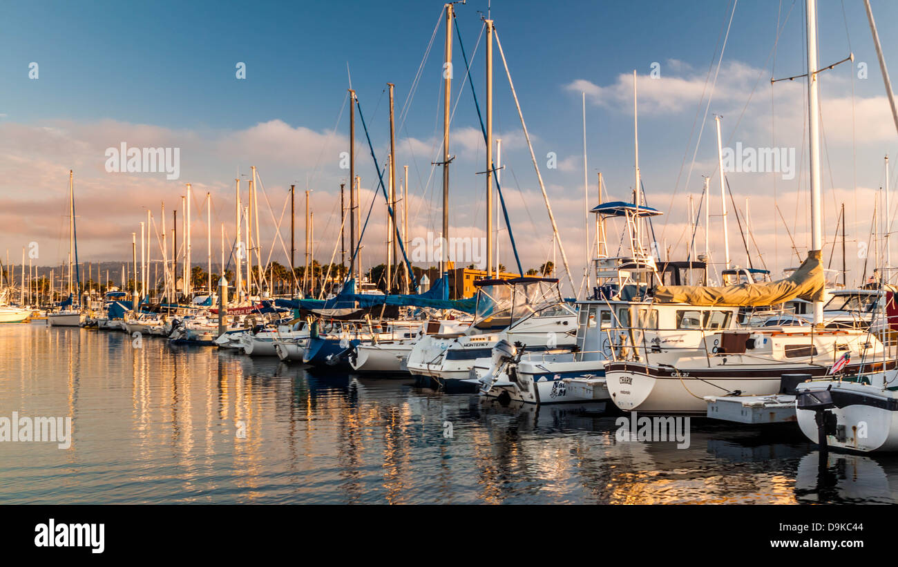 Barche e yacht di piccole dimensioni allineate in un Californian Marina al tramonto Foto Stock