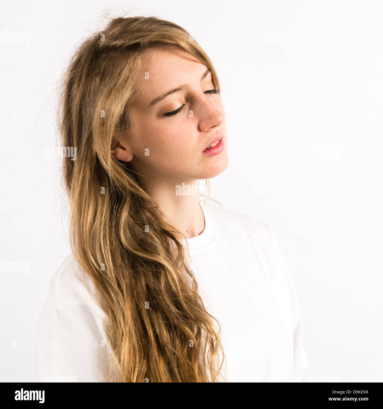 Una giovane donna con capelli lunghi biondi con gli occhi chiusi a sognare  di pensare Foto stock - Alamy