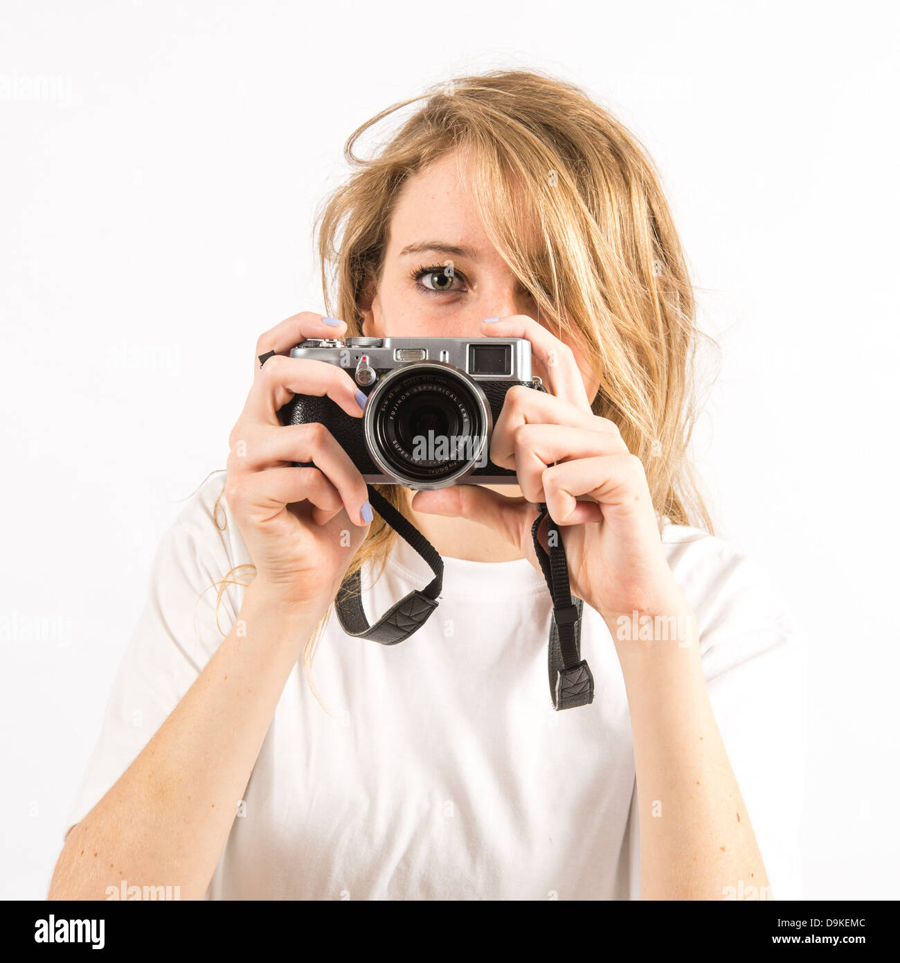 Una giovane donna fotografa con lunghi capelli biondi utilizzando una piccola Fuji X100 s fotocamera digitale Foto Stock