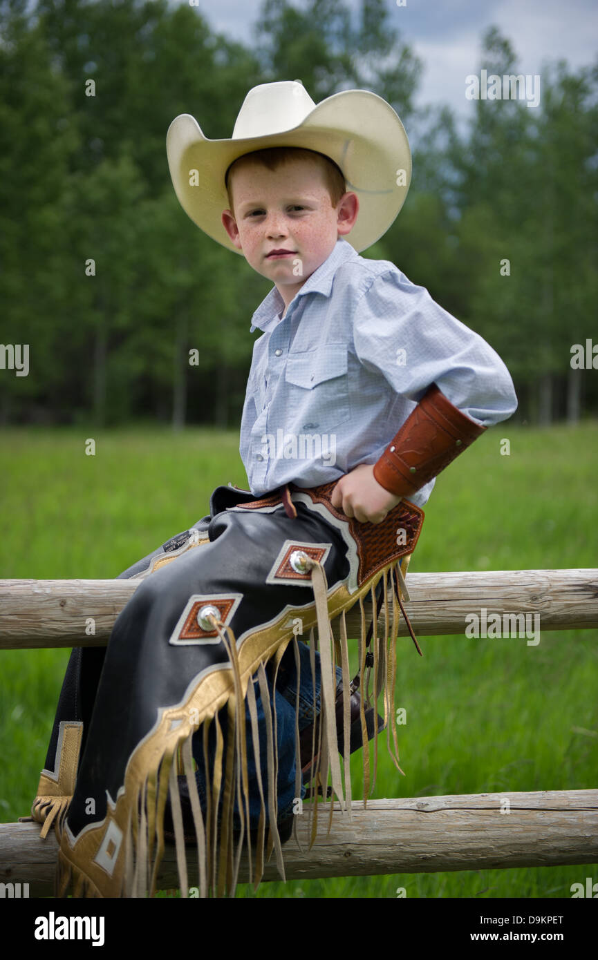 Giovani cowboy sul recinto con la sua chaps. Foto Stock