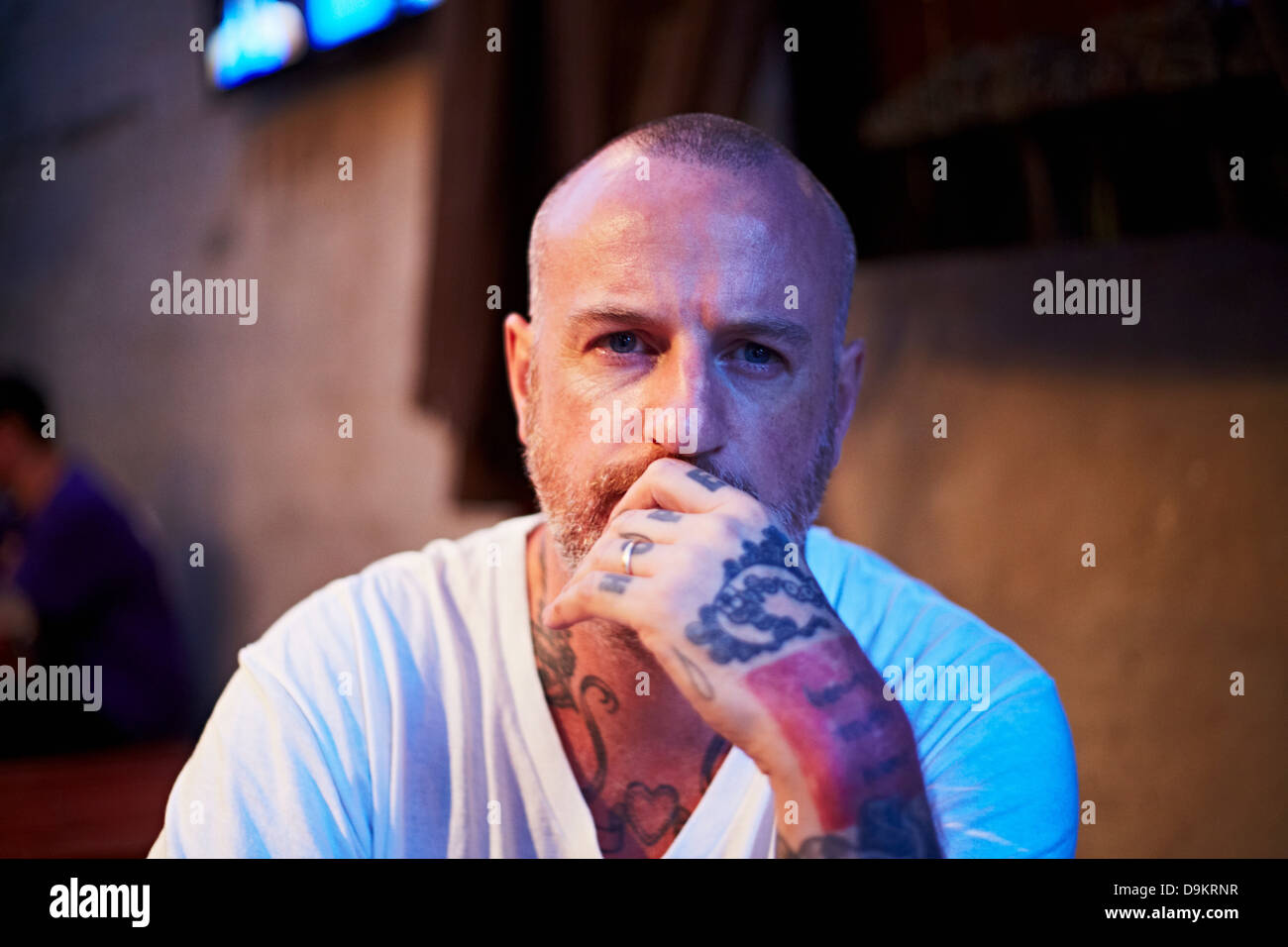 L'uomo con la testa rasata e tatuaggi Foto Stock