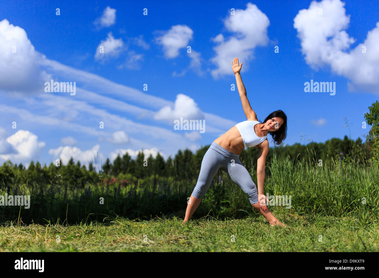 Ragazza fare yoga outdoor cercando nella fotocamera, ladscape Foto Stock