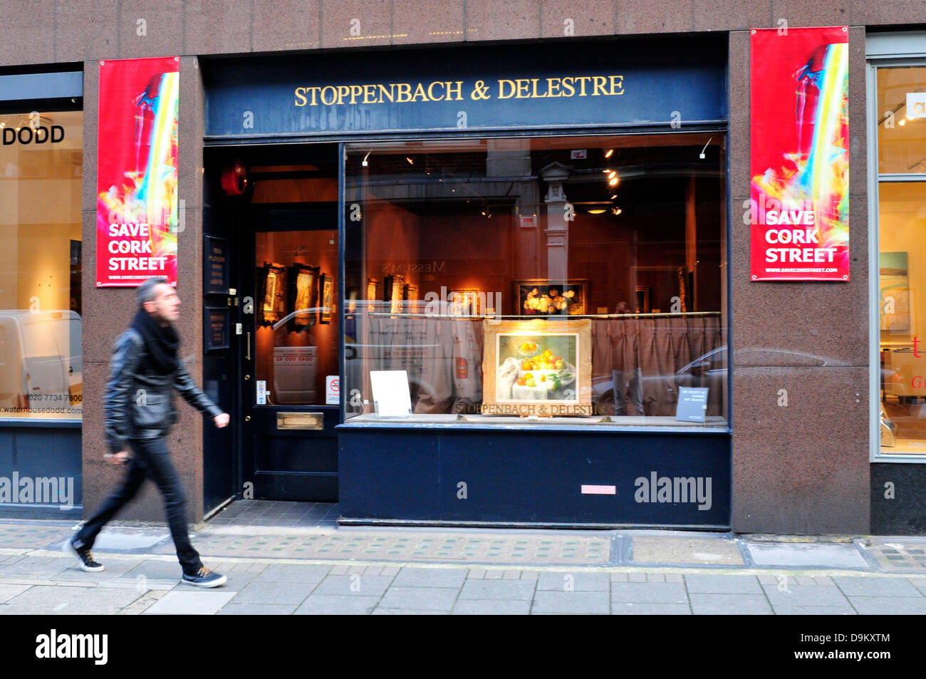 Un uomo cammina passato una galleria d'arte a Cork Street, Londra, Regno Unito. Foto Stock