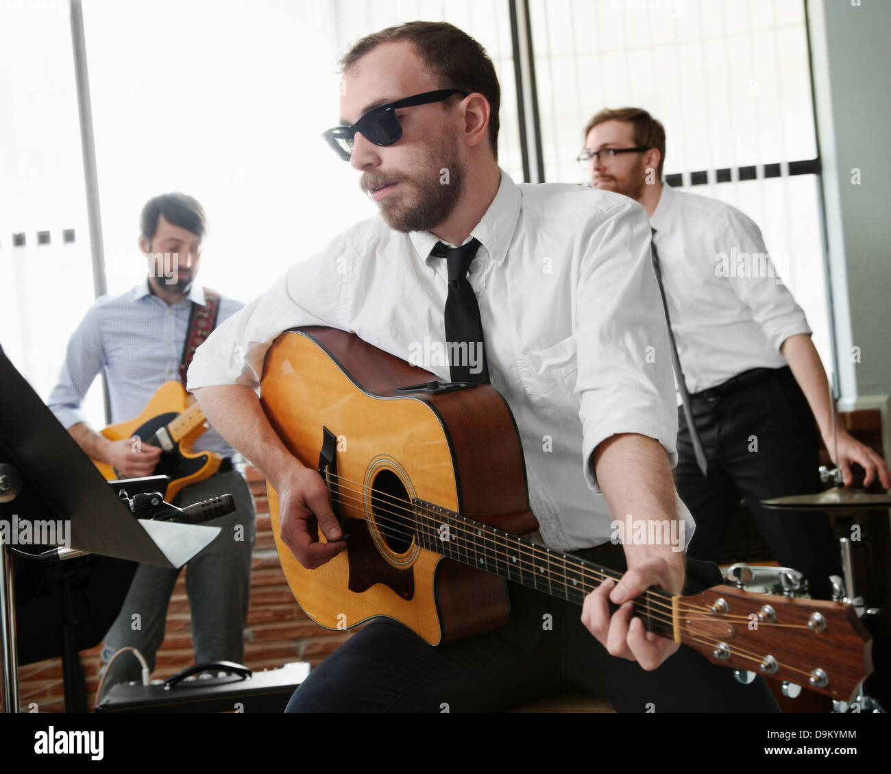 Giovane uomo a suonare la chitarra in sala prove Foto Stock