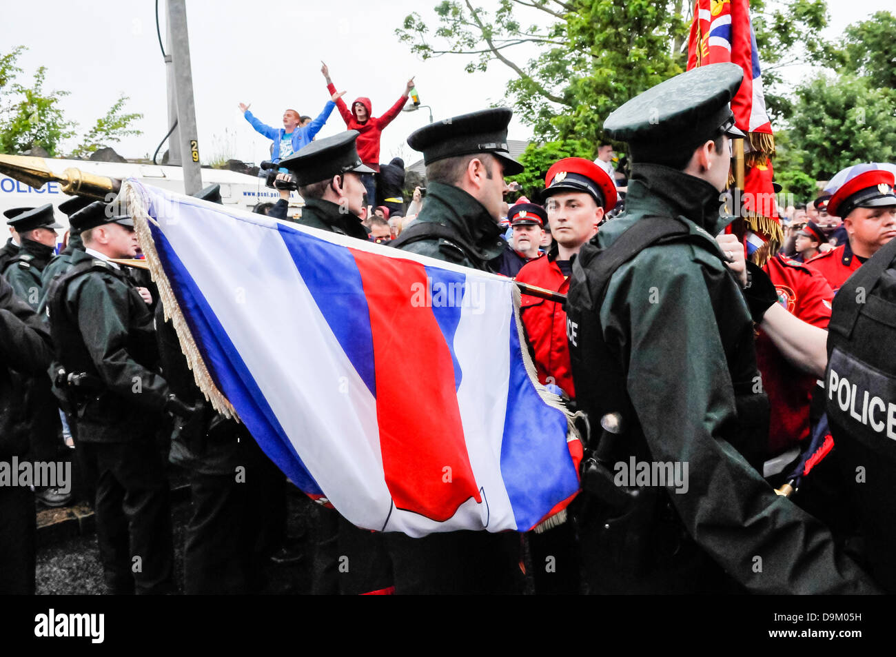 Belfast, Irlanda del Nord. Il 21 giugno 2013. Una banda di lealisti partito colore abbassa le bandiere attraverso la linea di polizia cantando "Dio salva la nostra Regina' Credit: stephen Barnes/Alamy Live News Foto Stock