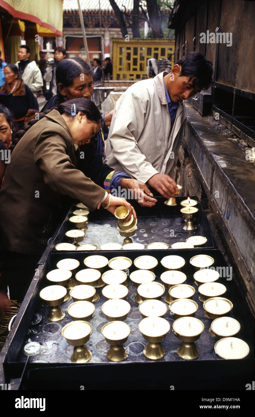 I pellegrini tibetani illuminano lampade di burro nel monastero tibetano Gompa Kumbum chiamato anche Tempio di Ta'er fondato nel 1583 in una stretta valle vicino al villaggio di Lusar nella storica regione tibetana di Amdo nella contea di Huangzhong, a Xining, la capitale della provincia di Qinghai nella Cina occidentale Foto Stock