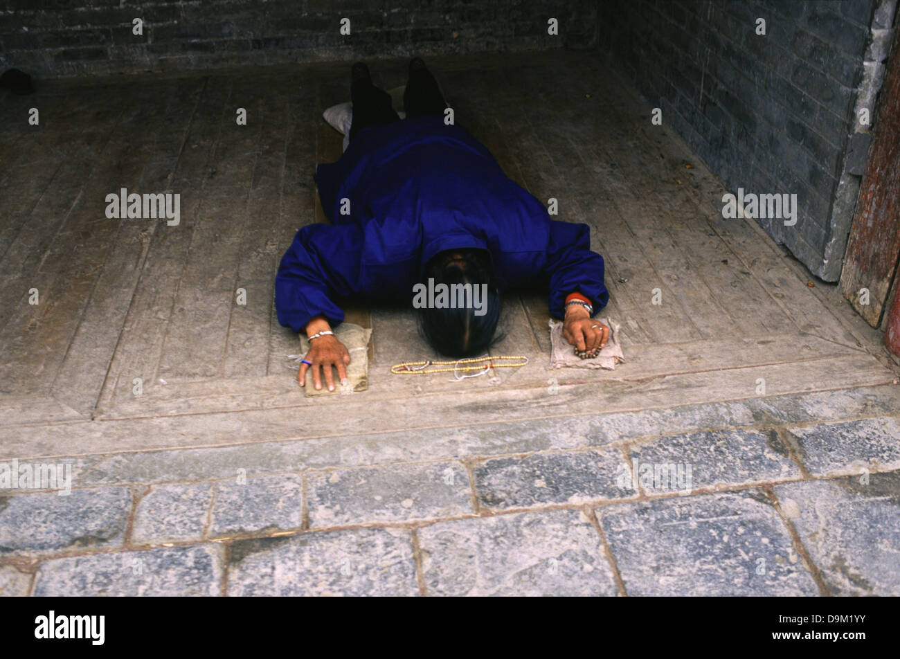 Buddista Tibetana adoratore prostrarsi in tibetano Kumbum gompa monastero chiamato anche Ta'er tempio fondata nel 1583 in una valle stretta vicino al villaggio di Lusar nella storica regione tibetana di Amdo nella contea di Huangzhong, in Xining la capitale della Provincia di Qinghai in Cina occidentale Foto Stock