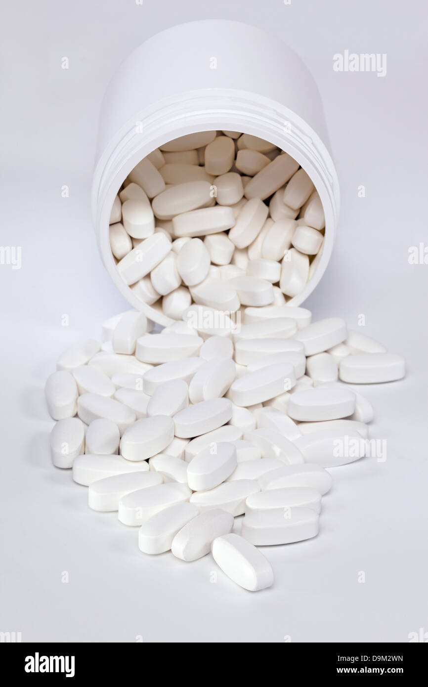 Compresse fuoriuscita dal contenitore - vitamina pillole fuoriuscita da un contenitore in plastica. Foto Stock