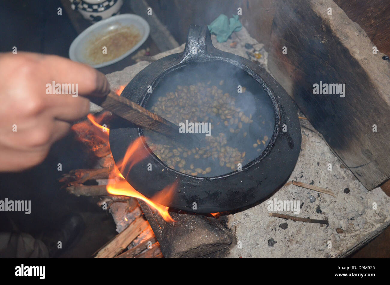 Un uomo su una piantagione di caffè arrosti i chicchi di caffè per fare caffè fresco. Santa Teresa, Cusco, Perù Foto Stock