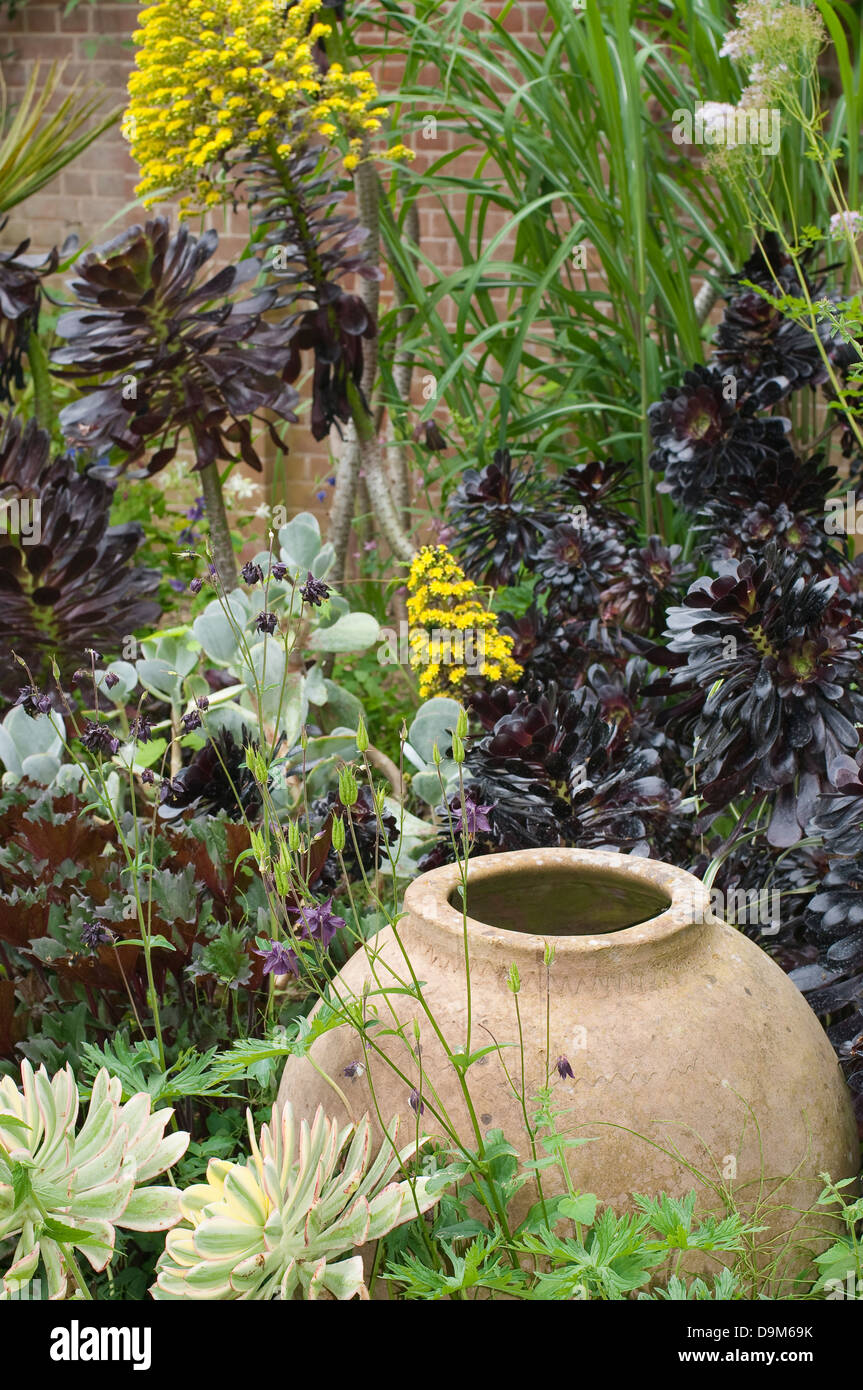 Garden design. Vaso in ceramica tra i fiori. Foto Stock