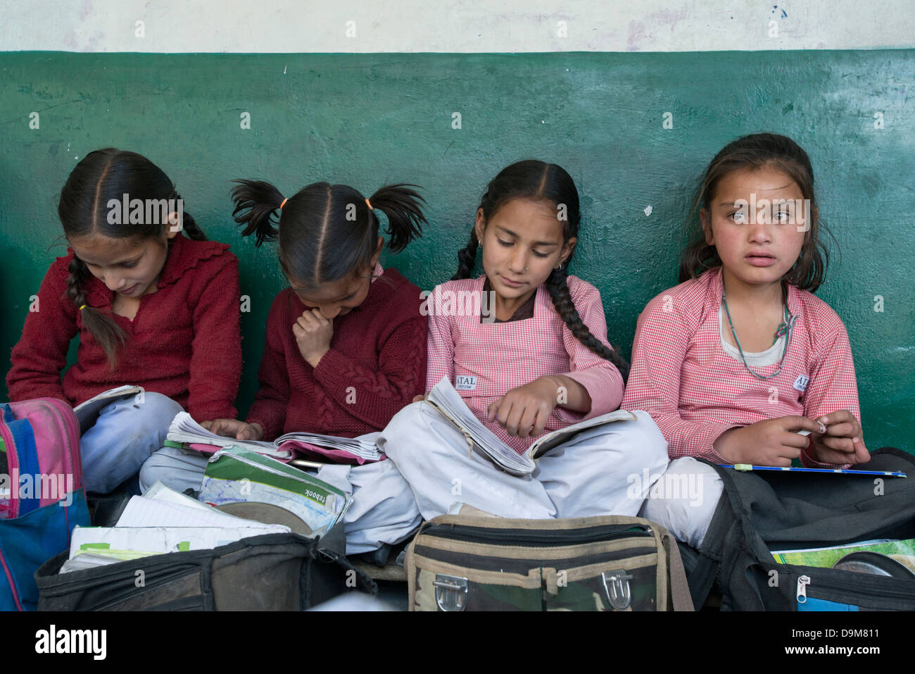 Indian scolari di leggere al di fuori della loro classe nel distretto tribale di Bharmour, Himachal Pradesh, India Foto Stock