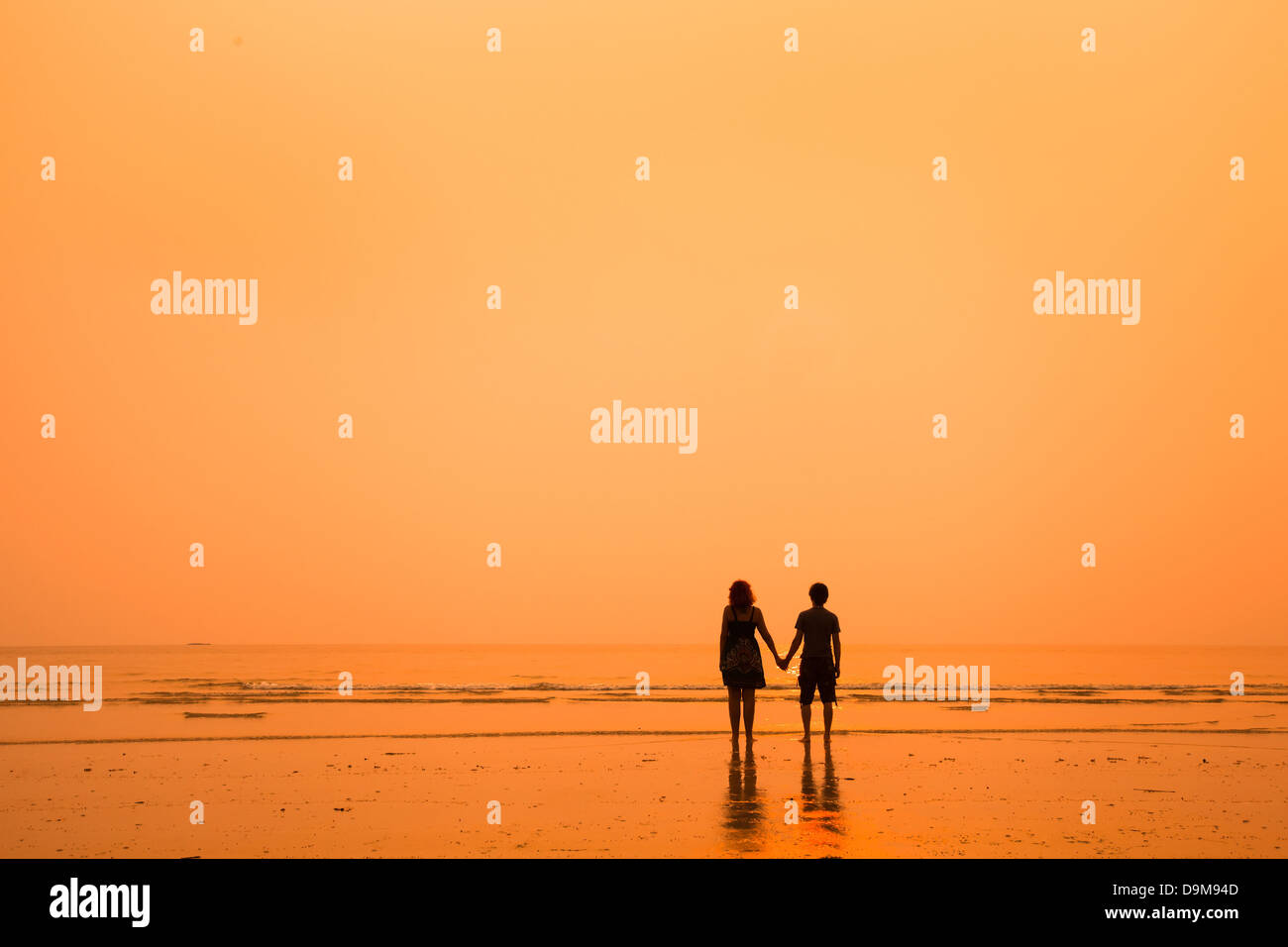 Sunset silhouettes di amare giovane sulla spiaggia Foto Stock