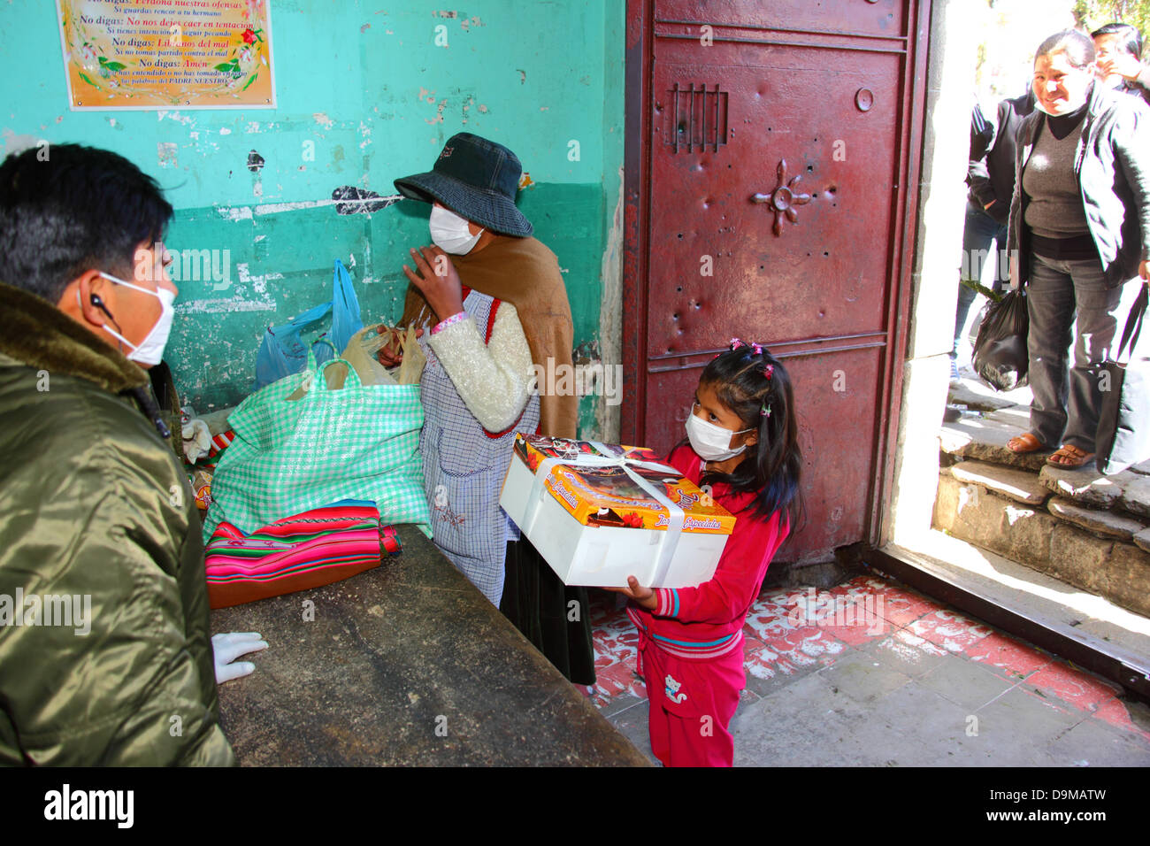 La Paz, Bolivia. 22 giugno 2013. Una ragazza attende con una torta di compleanno, mentre la polizia cerca i beni della madre durante un controllo di sicurezza prima di visitare i parenti incarcerati nella prigione di San Pedro. Foto Stock