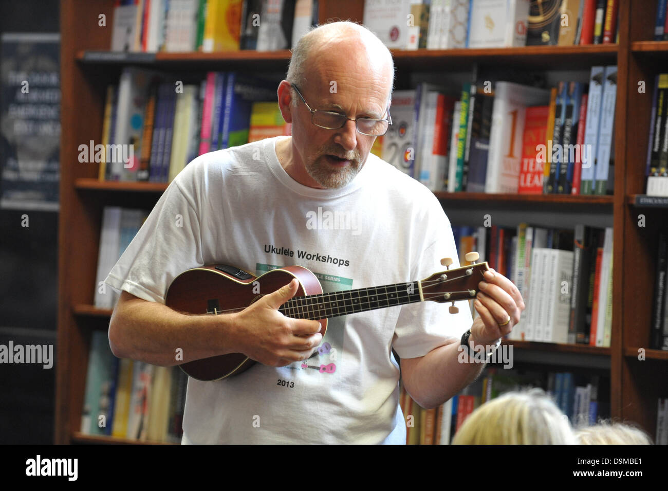 Blackwells Bookshop, Charing Cross Road, Londra, Regno Unito. Il 22 giugno 2013. Ukulele mago Ian Lawrence insegna alle persone di giocare l'ukulele al 'Ukulele parte" in Blackwells bookshop un'attività come parte del Charing Cross Road Fest 2013. Credito: Matteo Chattle/Alamy Live News Foto Stock