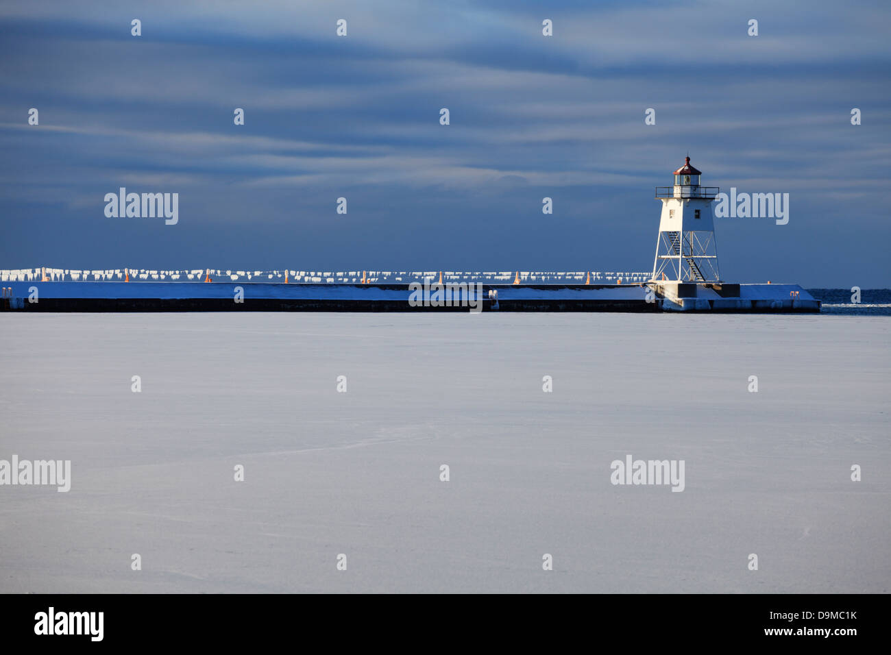 Vista mattutina del faro Break water e scintillanti cavi ricoperti di ghiaccio in inverno. Grand Marais, Minnesota, Stati Uniti. Foto Stock