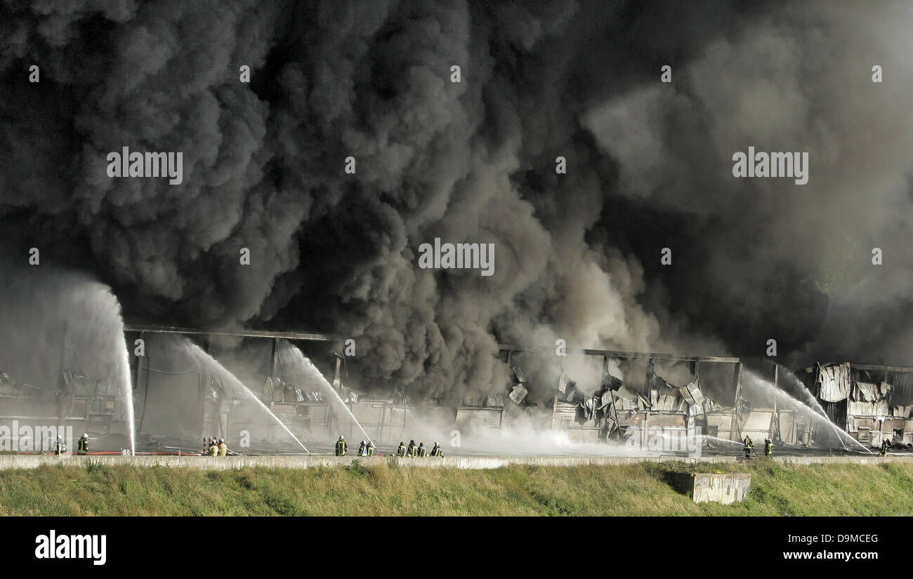 Ludwigshafen, Germania. Il 22 giugno, 2013. I vigili del fuoco di spegnere un incendio in Ludwigshafen, Germania, 22 giugno 2013. Un grave incendio in un magazzino a Ludwigshafen ha causato un enorme pilastro di fumo. Foto: FREDRIK VON ERICHSEN/dpa/Alamy Live News Foto Stock