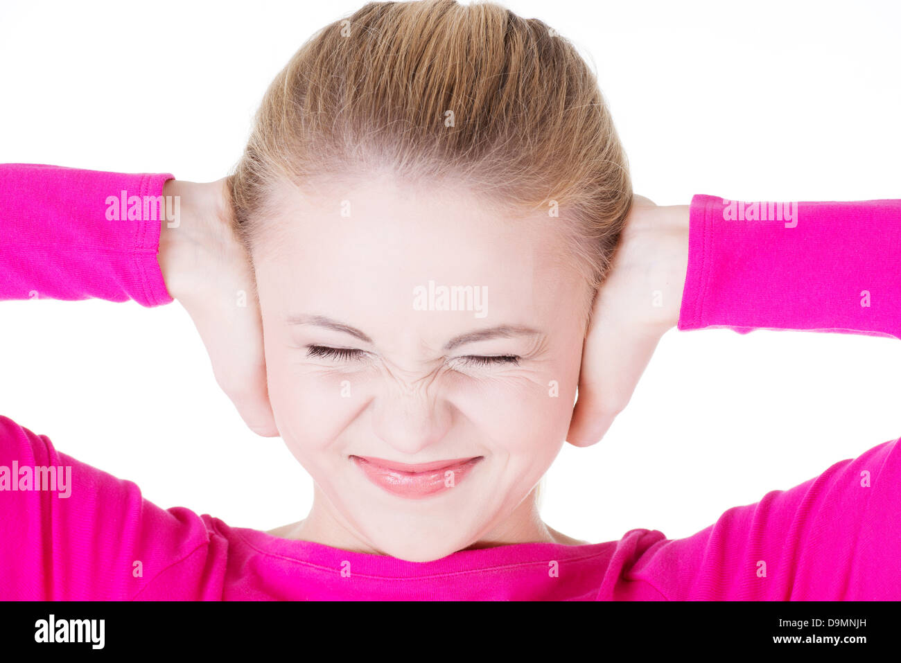 Primo piano della frustrato giovane donna tenendo le sue orecchie, isolato su bianco Foto Stock