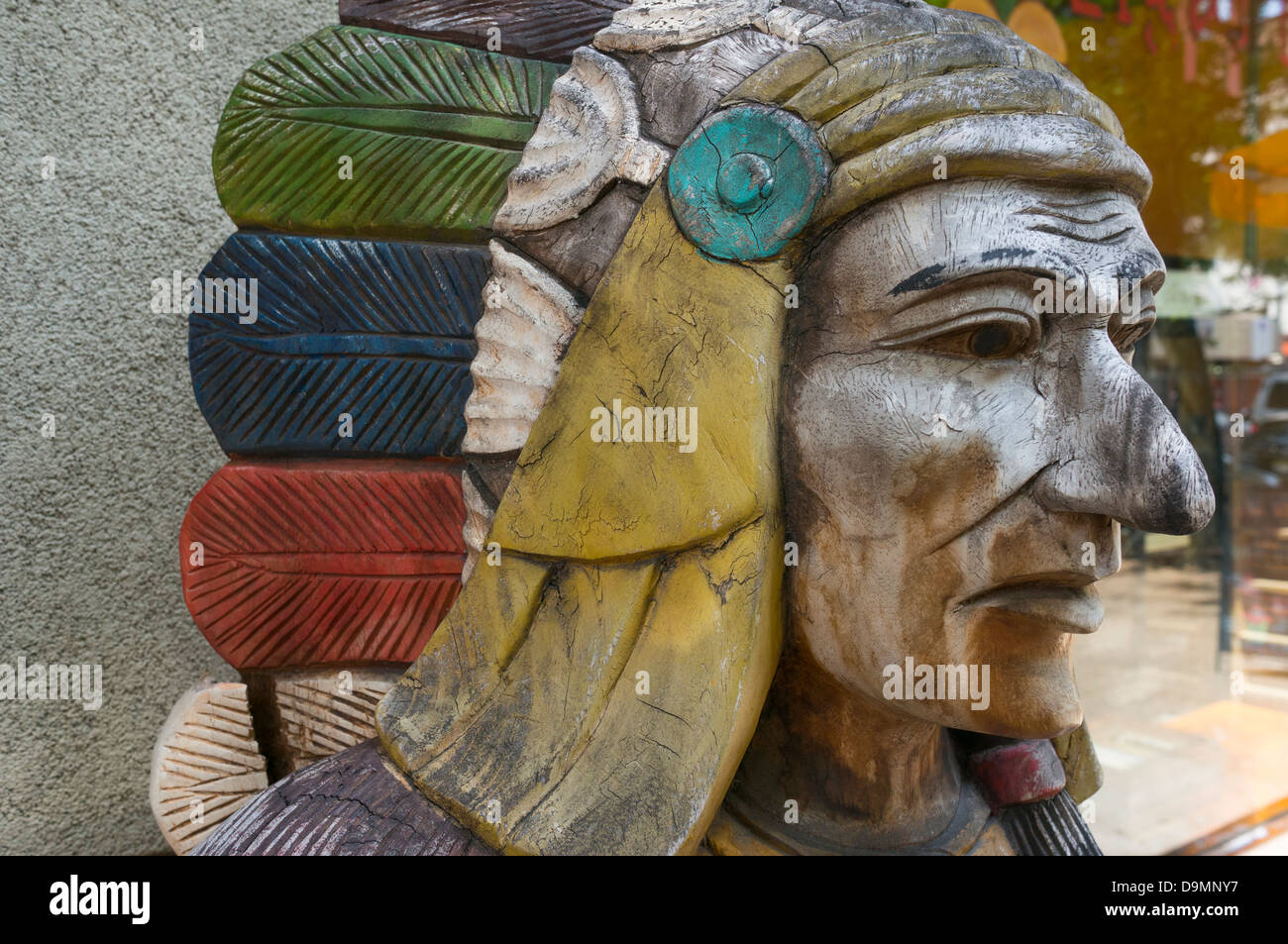 Il sigaro-store intagliato indiano di legno con un copricapo di piume, probabilmente Sioux Lakota Foto Stock