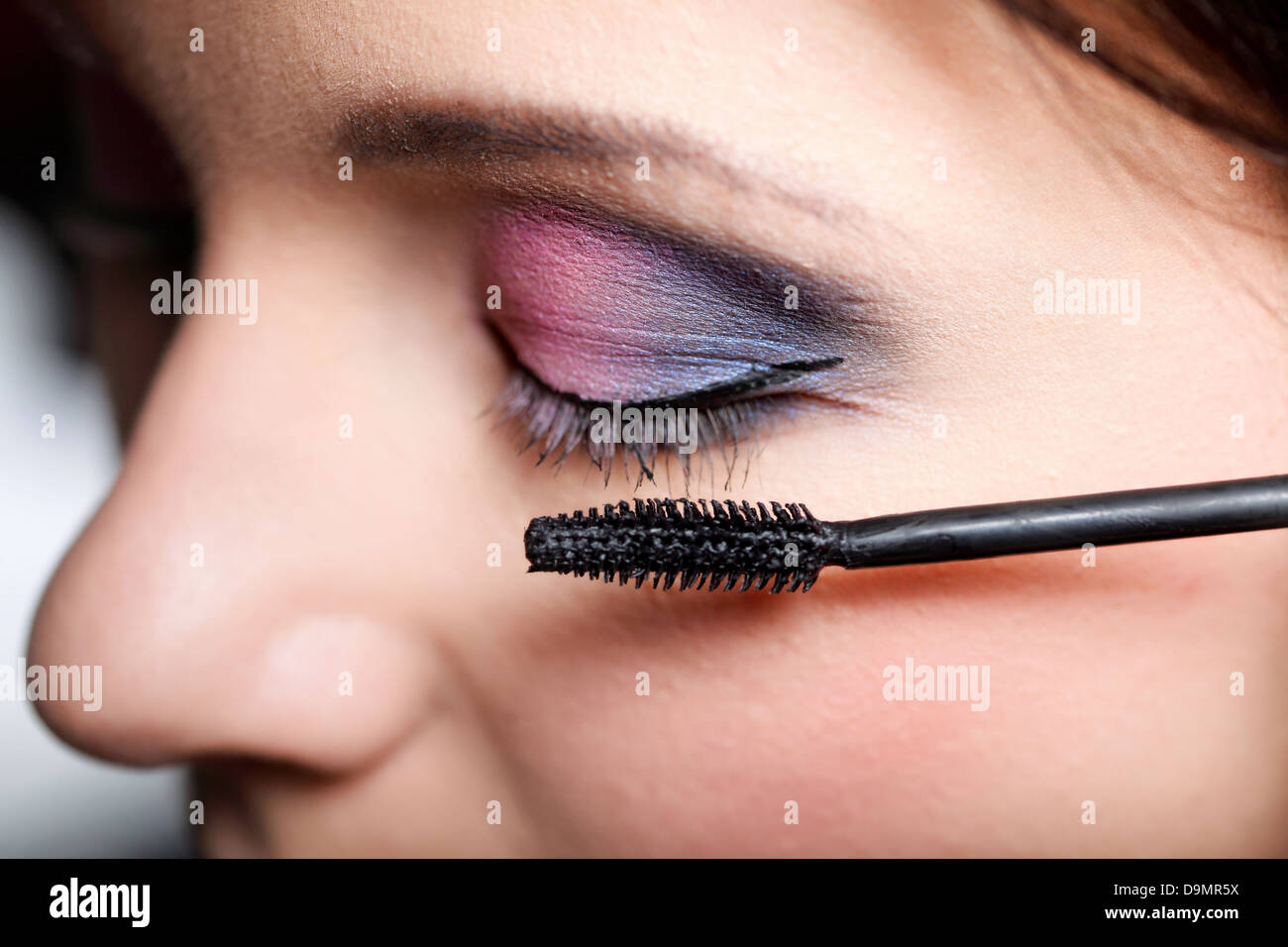 Closeup donna giovane applicazione di mascara trucco degli occhi a pennello Foto Stock