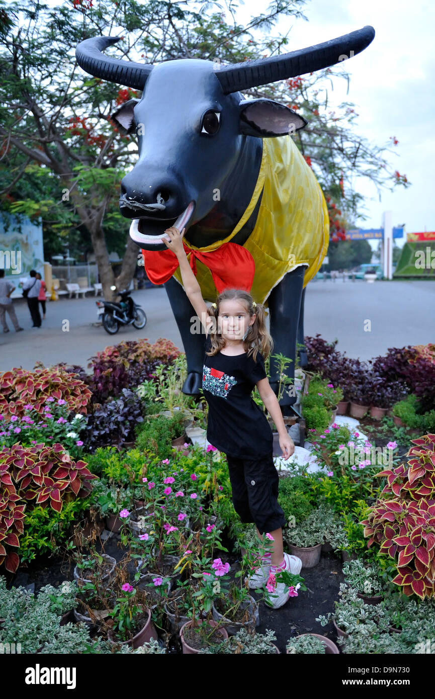 7 anno di età bambino con appositamente decorate statua commemora 2009, l'Anno del Bue. Tay Ninh, Vietnam Foto Stock